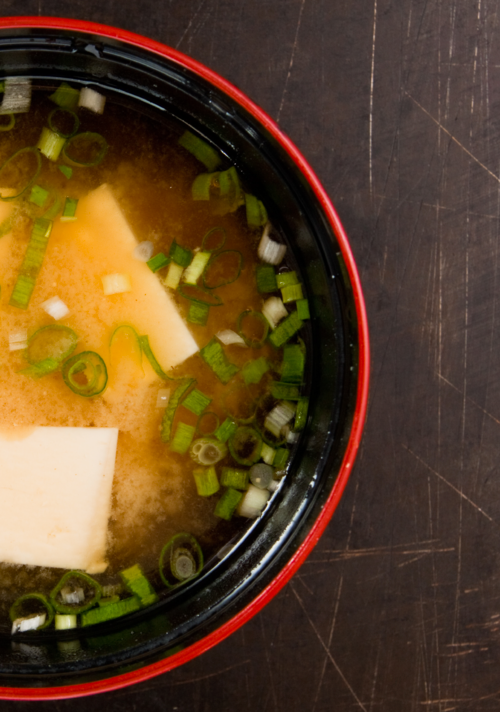 top view shot of a bowl of Vegan Miso soup with tofu and garnished with chopped onion chives.