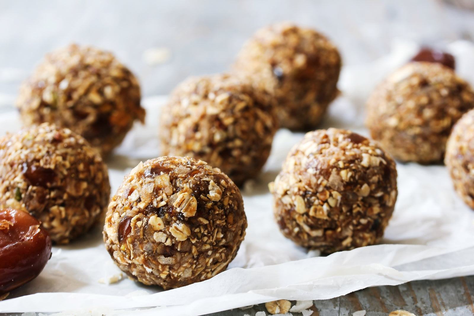 side view of a nutty pineapple chia clusters on top of a parchment paper with one date on the side
