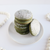 a stack of matcha-flavored cookies on a white saucer sprinkled with powdered sugar.