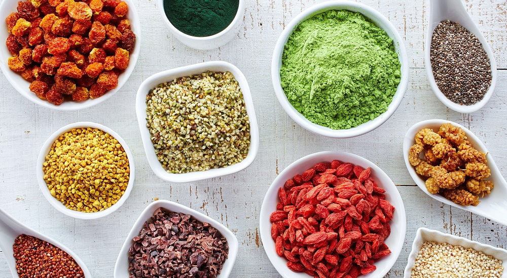 Top view image of multiple bowls of variety of nuts and grains. 