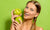 Happy glowing girl holding green apples on a green background