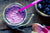 a jar of purple power smoothie with lavender plastic straw and string on the neck of the jar with a bowl of berries on the side and a checkered table clothe