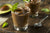 Thick chocolate avocado smoothie on a wooden table garnished with mint leaves