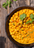 top view shot of a bowl of chickpeas curry on a wooden table