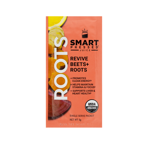 A red colored sachet of Smart Pressed Revive Beets & Roots, which has cover art containing a lemon slice, turmeric slices, and a slice of beets. The text reads Roots, Revive Beets and Roots, promotes clean energy, helps maintain stamina & focus, supports liver & heart health, single serving packet, 8 grams. Contains the USDA certified organic logo